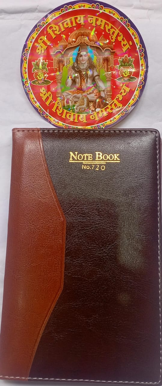 Brown notebook with gold accents and a circular decorative item on a white background