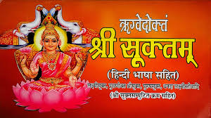 Hindu goddess on a pink lotus with text in Hindi on an orange background