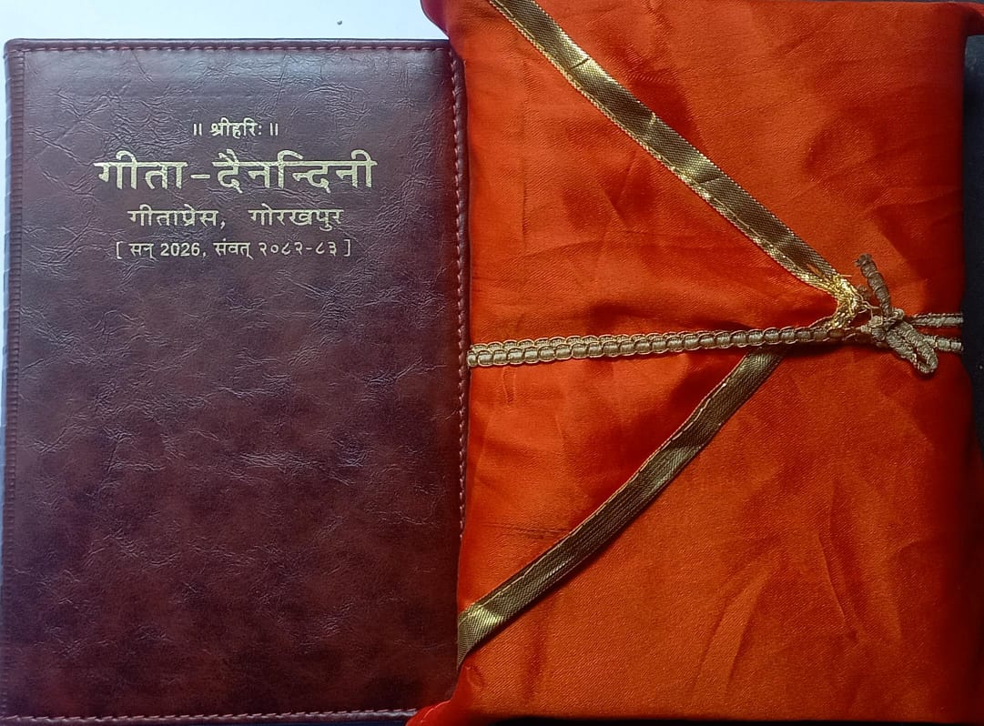 Brown leather-bound book with gold thread on an orange fabric background