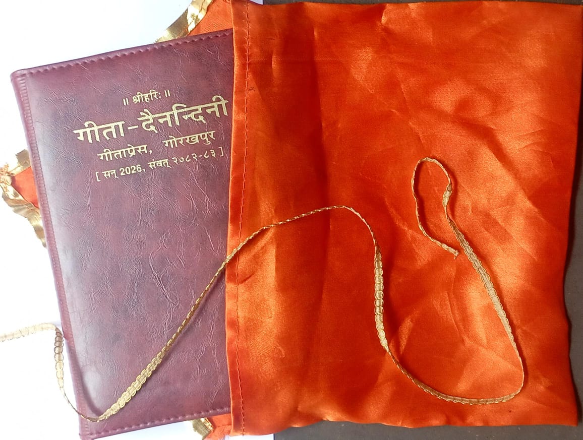 Purple book with gold text and an orange bag with a gold cord on a dark background