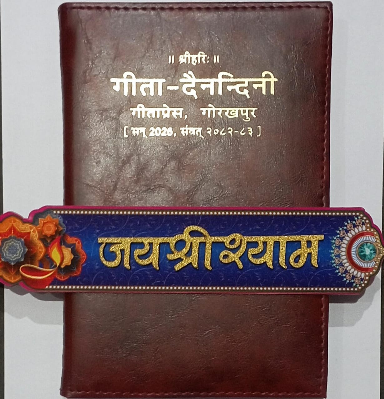 Gita Dainandini Leather Diary 2026 (Deluxe Edition) by Gita Press Gorakhpur. Includes Hindi Panchang Calendar, Festivals, गीता जयंती Details, and Daily Planner Pages. Ideal for Home, Temple, and Office use Free Multicolor Wooden Sticker Jai Shree Shyam with Khatu Shyam