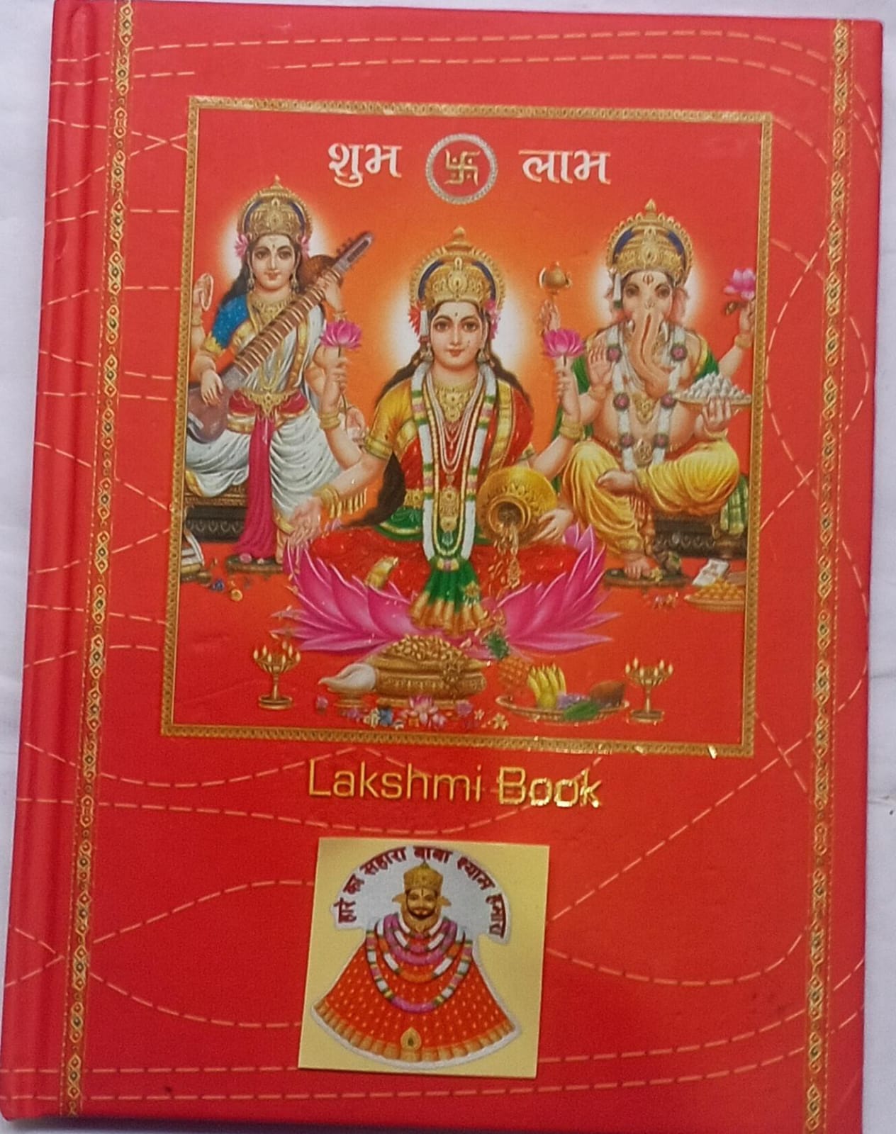 Red book cover with illustrations of deities and 'Lakshmi Book' text on a white background