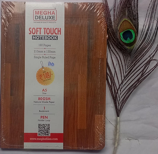 Wooden notebook with Megha Deluxe packaging and a peacock feather on a marble surface